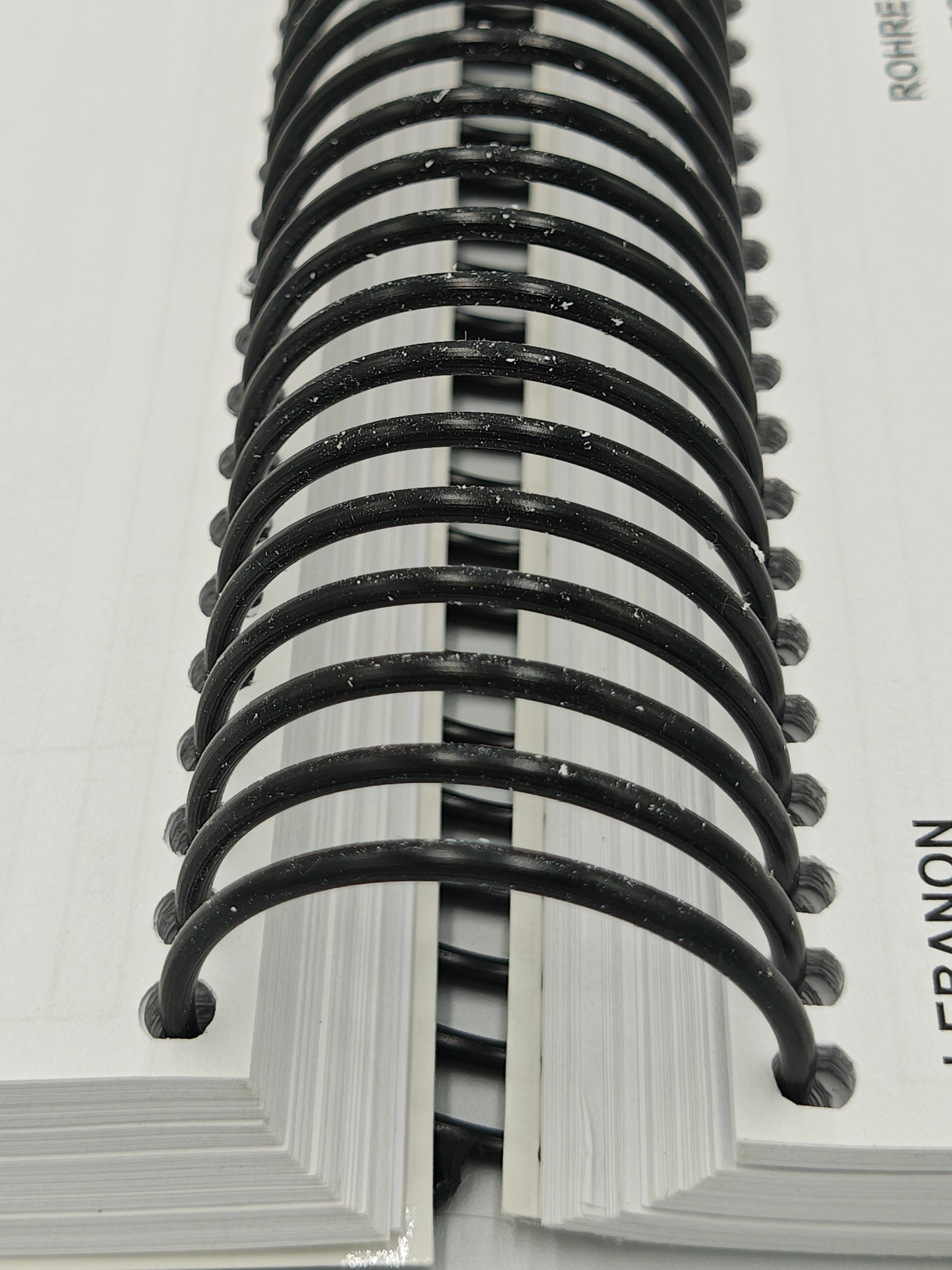 Close up of thick black spiral binding of white pages